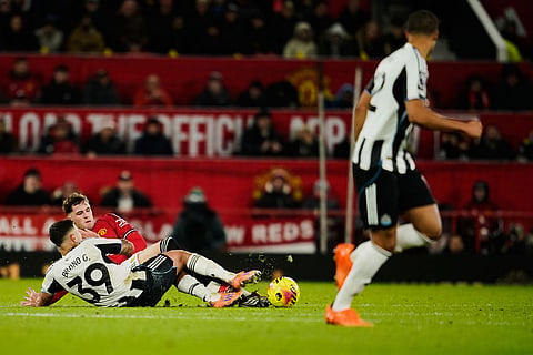Newcastle's Bruno Guimaraes, right, fights for the ball with Manchester United's Jack Fletcher during the English Premier League soccer match between Manchester United and Newcastle in Manchester, England.