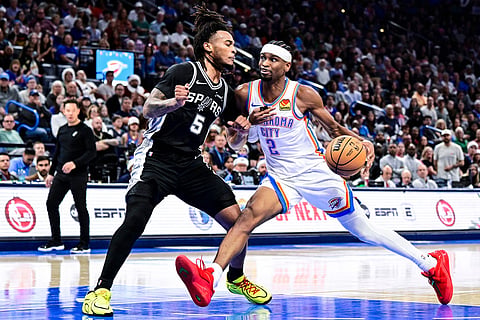 Oklahoma City Thunder guard Shai Gilgeous-Alexander (2) drives against San Antonio Spurs guard Stephon Castle (5) during the second half of an NBA basketball game, in Oklahoma City.