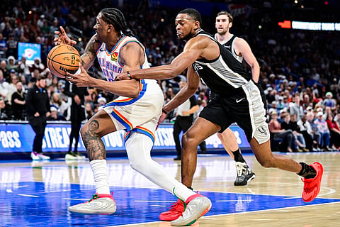 San Antonio Spurs guard De'Aaron Fox (4) foul against Oklahoma City Thunder guard/forward Jalen Williams (8) during the second half of an NBA basketball game in Oklahoma City. 