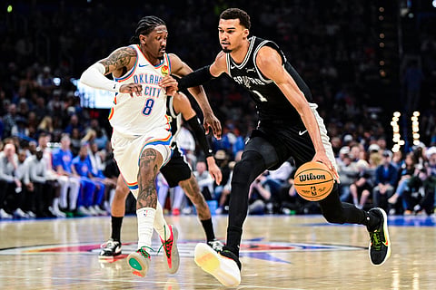 San Antonio Spurs Victor Wembanyama (1) drives against Oklahoma City Thunder guard/forward Jalen Williams (8) during the first half of an NBA basketball game in Oklahoma City. 