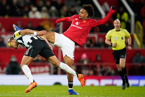 Manchester United's Joshua Zirkzee, center, fights for the ball with Newcastle's Malick Thiaw, left, during the English Premier League soccer match between Manchester United and Newcastle in Manchester, England.