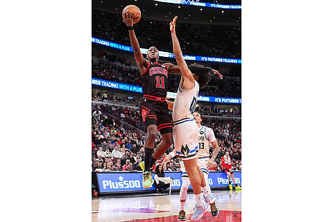 Chicago Bulls guard Ayo Dosunmu, left, drives to the basket against Milwaukee Bucks center Jericho Sims during the second half of an NBA basketball game in Chicago.