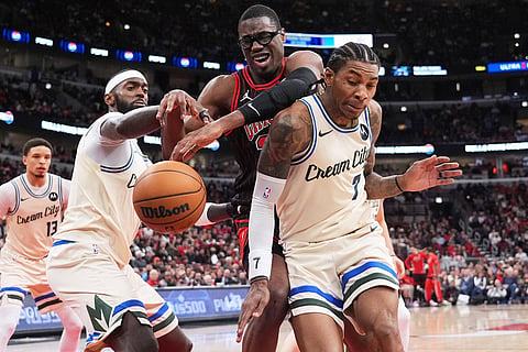 Chicago Bulls forward Jalen Smith, center, battles for a loose ball against Milwaukee Bucks forward Bobby Portis Jr., left, and guard Kevin Porter Jr. during the second half of an NBA basketball game in Chicago.