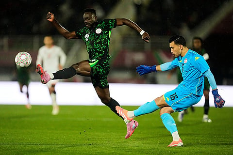 Tunisia's goalkeeper Aymen Dahmen, right, kicks the ball as Nigeria's Akor Adams tries to block the ball during the Africa Cup of Nations group C soccer match between Nigeria and Tunisia in Fez, Morocco.