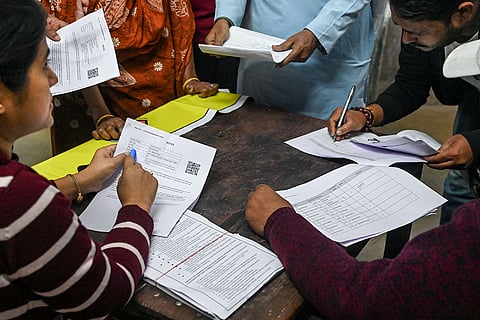 People gather at a school during a hearing under the Special Intensive Revision (SIR) of electoral rolls, in Kolkata, West Bengal.