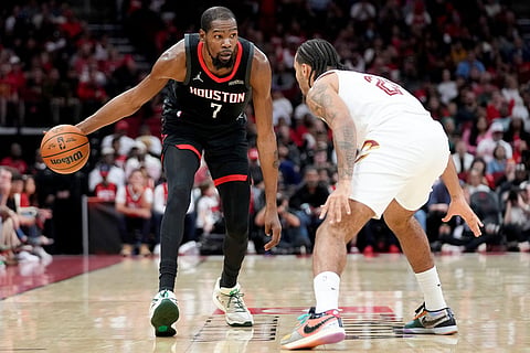 Houston Rockets forward Kevin Durant (7) dribbles as Cleveland Cavaliers guard Jaylon Tyson defends during the first half of an NBA basketball game in Houston.