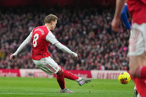 Arsenal's Martin Odegaard scores the opening goal during the English Premier League soccer match between Arsenal and Brighton and Hove Albion in London.