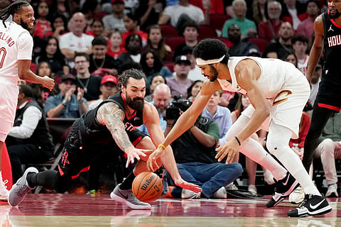 Houston Rockets center Steven Adams, left, and Cleveland Cavaliers center Jarrett Allen compete for a loose ball during the first half of an NBA basketball game in Houston.