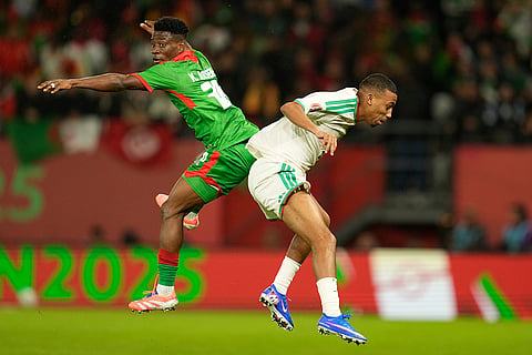 Burkina Faso's Gustavo Sangare, left, competes for the header with Algeria's Rafik Belghali during the Africa Cup of Nations group E soccer match between Algeria and Burkina Faso in Rabat, Morocco.