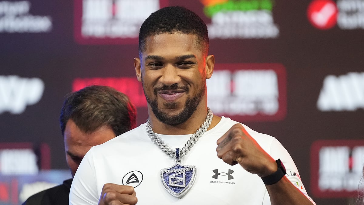 (AP Photo/Lynne Sladky) : Anthony Joshua stands on stage during a face-off against Jake Paul at a news conference promoting their upcoming heavyweight boxing match, Wednesday, Dec. 17, 2025, in Miami Beach, Fla. 