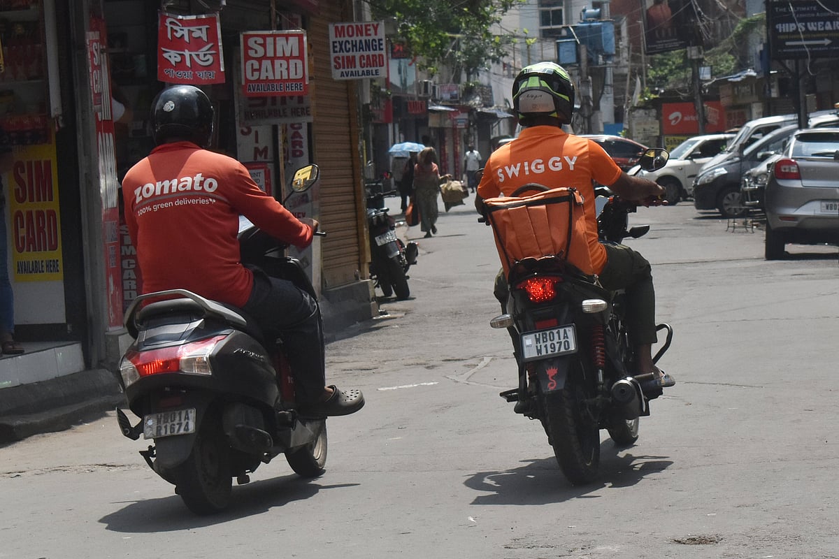 App based food delivery persons from Zomato and Swiggy delivering food in Kolkata, India - Source: IMAGO / NurPhoto 