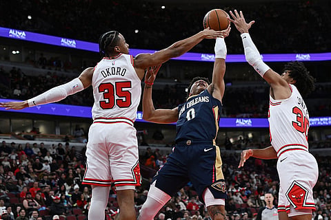New Orleans Pelicans' Jeremiah Fears (0) goes up for a shot against Chicago Bulls' Isaac Okoro (35) and Tre Jones (30) during the first half of an NBA basketball game in Chicago.