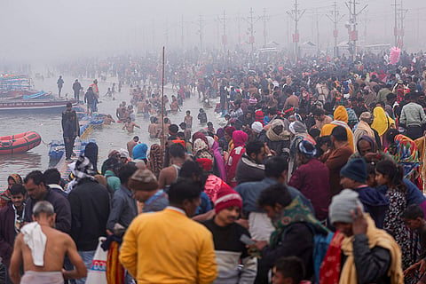 Devotees gather amid fog to take a dip on the first day of the year, in Prayagraj.