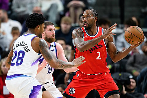 Los Angeles Clippers forward Kawhi Leonard (2) controls the ball while under pressure from Utah Jazz forward Brice Sensabaugh (28) and guard Svi Mykhailiuk (10) during the second half of an NBA basketball game in Inglewood, California.
