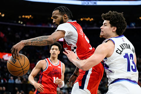 Los Angeles Clippers forward Derrick Jones Jr., center, goes for a rebound while under pressure from Utah Jazz guard Walter Clayton Jr. (13) during the second half of an NBA basketball game in Inglewood, California. 