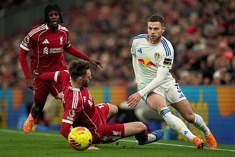 Leeds' Gabriel Gudmundsson, right, and Liverpool's Conor Bradley, center, challenge for the ball during the English Premier League soccer match between Liverpool and Leeds United in Liverpool, England.