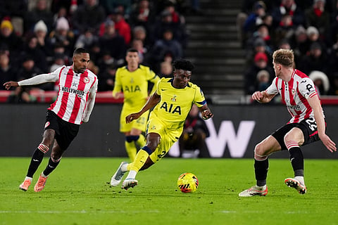 Tottenham Hotspur's Mohammed Kudus in action with Brentford's Rico Henry, left, and Nathan Collins during the English Premier League soccer match between Brentford and Tottenham Hotspur in London.