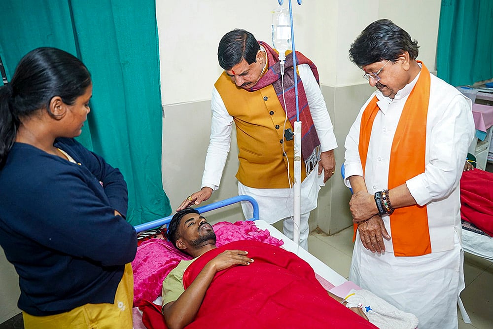 | Photo: @DrMohanYadav51/X via PTI : Madhya Pradesh Chief Minister Mohan Yadav and Minister Kailash Vijayvargiya meet an affected person undergoing treatment after consumption of contaminated water, at a hospital in Indore. 