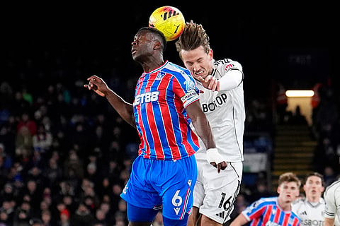 Crystal Palace's Marc Guehi, left, and Fulham's Sander Berge battle for the ball during their English Premier League soccer match in London.