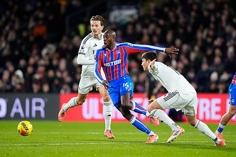Crystal Palace's Jean-Philippe Mateta, center, battles for the ball with Fulham's Sander Berge, left, and Jorge Cuenca during their English Premier League soccer match in London.