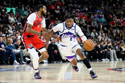 Utah Jazz guard Isaiah Collier (8) drives the ball past Los Angeles Clippers forward Derrick Jones Jr. (5) during the second half of an NBA basketball game in Inglewood, California.