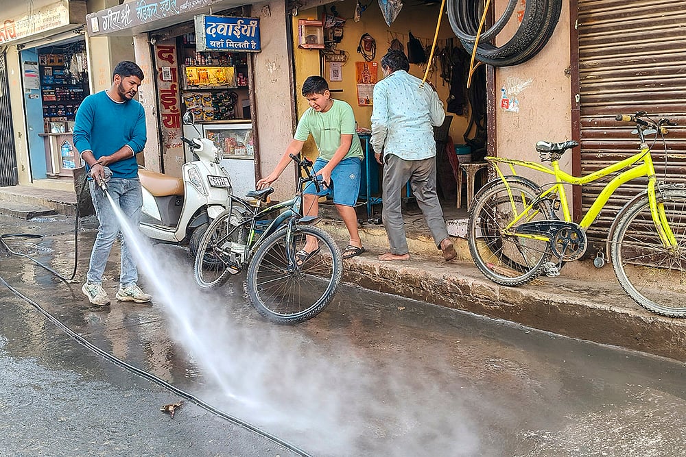 | Photo: PTI : An Indore Municipal Corporation worker during a cleanliness drive after several people were affected due to consumption of contaminated water at Bhagirathpura area, in Indore, Madhya Pradesh.