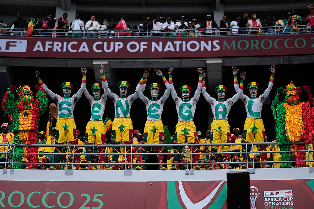 | Photo: AP/Themba Hadebe : Senegal fans support their national team during the Africa Cup of Nations group D soccer match between Senegal and DR Congo in Tangier, Morocco, Saturday, Dec. 27, 2025. 