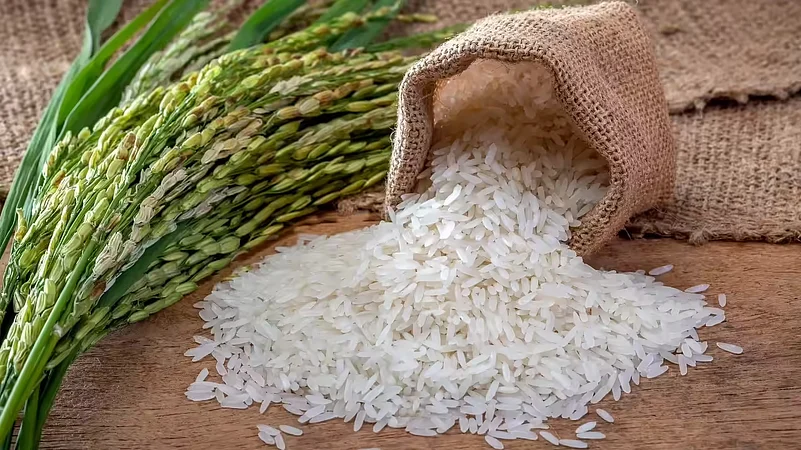 A pile of raw white rice spilling from a burlap sack onto a wooden surface