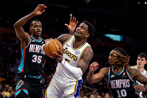 Los Angeles Lakers center Deandre Ayton (5) drives the ball against Memphis Grizzlies center Christian Koloko (35) and Memphis Grizzlies guard Javon Small (10) during the second half of an NBA basketball game in Los Angeles. 