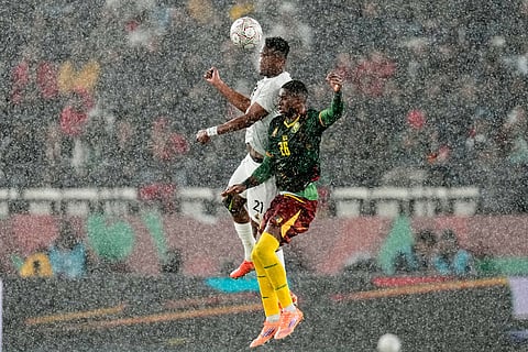 South Africa's Siyabonga Ngezana and Cameroon's Christian Kofane challenge for the ball in the rain during the Africa Cup of Nations round of 16 soccer match between South Africa and Cameroon in Rabat, Morocco.