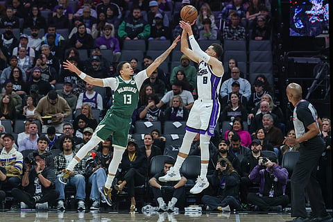 Sacramento Kings guard Zach Lavine (8) makes a jump shot over Milwaukee Bucks guard Ryan Rollins (13) during the first half of an NBA basketball game in Sacramento, California.