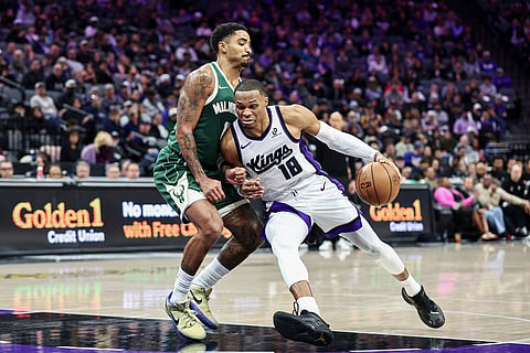 Sacramento Kings guard Russell Westbrook (18) drives to the basket with Milwaukee Bucks guard Gary Harris, left, defending during the second half of an NBA basketball game in Sacramento, California.