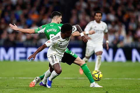Real Madrid's Rodrygo, front, challenges Betis' Marc Bertra during the Spanish La Liga soccer match between Real Madrid and Real Betis Sevilla in Madrid, Spain.