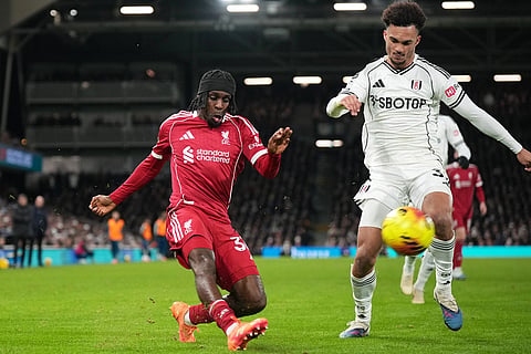 Liverpool's Jeremie Frimpong, left, challenges for the ball with Fulham's Calvin Bassey during the English Premier League soccer match between Fulham and Liverpool in London.