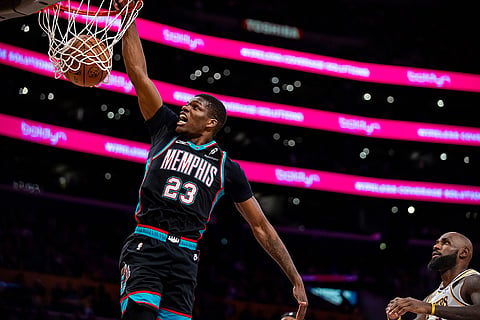 Memphis Grizzlies forward Cedric Coward dunks the ball against Los Angeles Lakers forward LeBron James during the first half of an NBA basketball game, in Los Angeles. 