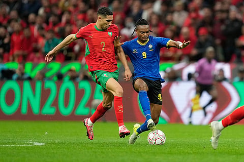 Morocco's Achraf Hakimi, left, is challenged by Tanzania's Selamani Mwalimu during the Africa Cup of Nations round of 16 soccer match between Morocco and Tanzania in Rabat, Morocco.