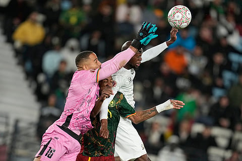 Cameroon's goalkeeper Devis Epassy, Cameroon's Samuel Kotto and South Africa's Evidence Makgopa, from left, challenge for the ball during the Africa Cup of Nations round of 16 soccer match between South Africa and Cameroon in Rabat, Morocco.