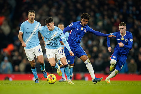 Manchester City's Phil Foden (47) dribbles the ball past Chelsea's Andrey Santos during the English Premier League soccer match between Manchester City and Chelsea in Manchester, England.