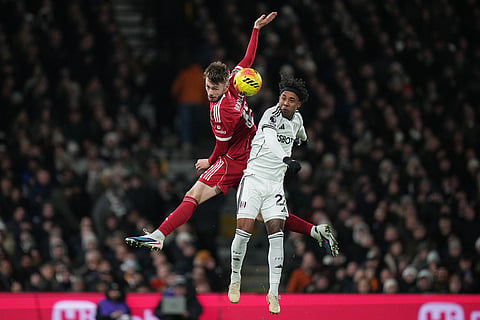 Liverpool's Conor Bradley jumps for a header with Fulham's Kevin during the English Premier League soccer match between Fulham and Liverpool in London.