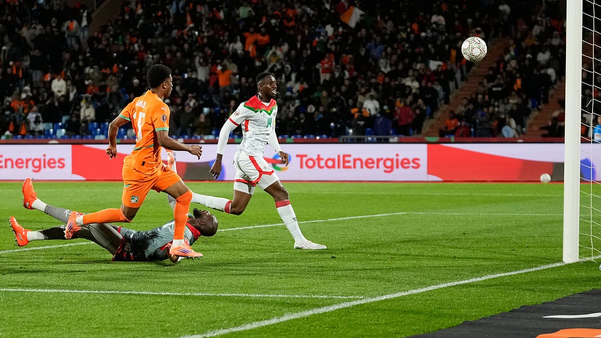 AP/Themba Hadebe : Ivory Coast's Amad Diallo, left, scores his sides first goal past Burkina Faso's Issoufou Dayo, right, and Burkina Faso's goalkeeper Kouakou Herve Koffi.