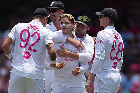 England's Jacob Bethell, centre, is congratulated bye teammates after dismissing Australia's Travis Head during play on day three of the fifth and final Ashes cricket test between England and Australia in Sydney.
