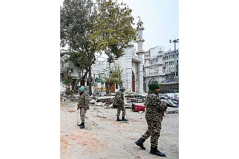 Security personnel stand guard outside the Syed Faiz Elahi mosque after the demolition of alleged encroachments from a land adjoining the mosque and a nearby graveyard carried out by the Municipal Corporation of Delhi (MCD), at Turkman Gate area, in New Delhi.