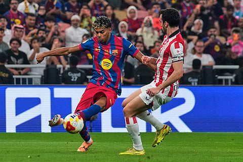 Barcelona's Lamine Yamal, left,31 kicks the ball during the Spanish Super Cup semifinal soccer match against Athletic Club Bilbao at King Abdullah Sports City Stadium in Jeddah, Saudi Arabia.