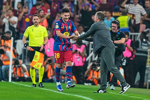 Barcelona's Roony Bardghji celebrates with Barcelona's head coach Hansi Flick after scoring the third goal during the Spanish Super Cup semifinal soccer match against Athletic Club Bilbao at King Abdullah Sports City Stadium in Jeddah, Saudi Arabia.