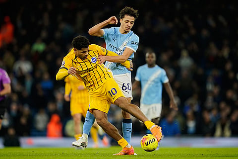 Brighton's Georginio Rutter, left, is challenged by Manchester City's Max Alleyne during the English Premier League soccer match between Manchester City and Brighton and Hove Albion in Manchester, England.
