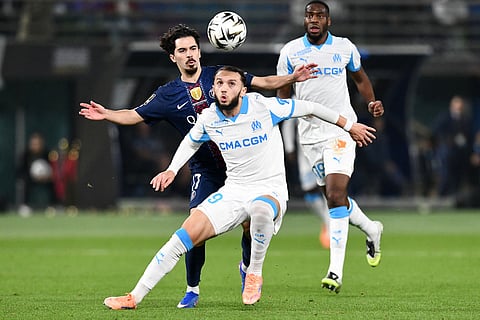 Marseille's Amine Gouiri shields the ball from PSG's Vitinha during the French Super Cup soccer match between PSG and Marseille in Kuwait City, Kuwait.
