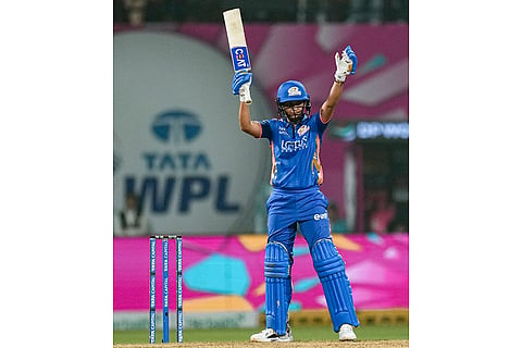 Mumbai Indians' captain Harmanpreet Kaur celebrates her half century during a Women's Premier League (WPL) T20 cricket match between Mumbai Indians and Delhi Capitals, at the DY Patil Stadium, in Navi Mumbai.