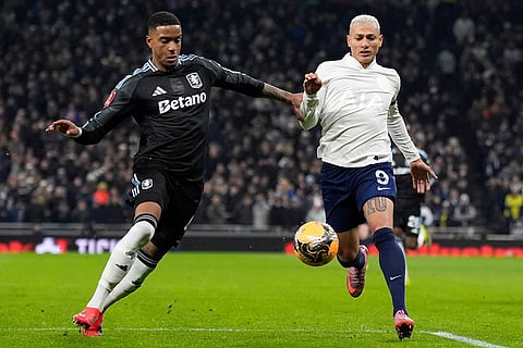 Tottenham Hotspur's Richarlison, right, races with Aston Villa's Ezri Konsa before pulling up with an injury during the FA Cup third round soccer match between Tottenham Hotspur and Aston Villa in London.