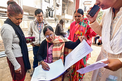 Voters check their names in the voter list during the Special Revision of Photo Electoral Rolls-2026 ahead of Assam Legislative Assembly elections, in Guwahati.