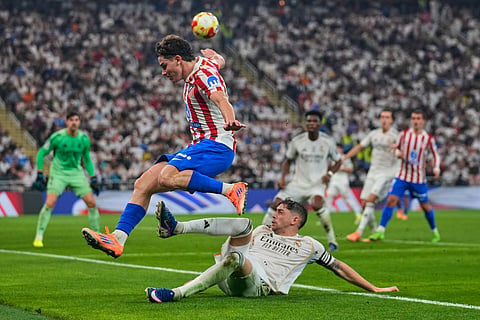 Atletico Madrid's Julian Alvarez is tackled by Real Madrid's Federico Valverde during the Spanish Super Cup semifinal soccer match at King Abdullah Sports City Stadium in Jeddah, Saudi Arabia.